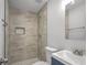 Modern bathroom featuring a tiled shower with a niche and a sleek vanity with mirror at 6565 Bussell Way, Riverdale, GA 30274
