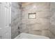 Bathroom featuring marble-look tile surround in shower and tub, framed niche at 6565 Bussell Way, Riverdale, GA 30274