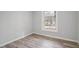 This bedroom has light gray walls, wood-look flooring, and a window at 6565 Bussell Way, Riverdale, GA 30274