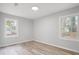 Bright bedroom with wood-look flooring, gray walls, and natural light from two windows at 6565 Bussell Way, Riverdale, GA 30274
