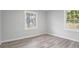 Light-filled bedroom with wood-look floors, neutral walls, and large windows offering ample natural light at 6565 Bussell Way, Riverdale, GA 30274