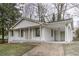 Charming white brick home featuring a covered front porch with classic columns and a matching carport at 6565 Bussell Way, Riverdale, GA 30274