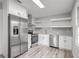 Modern kitchen with stainless steel appliances, white cabinets, gray subway tile backsplash, and floating shelves at 6565 Bussell Way, Riverdale, GA 30274