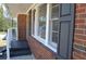 Close up of home with brickwork, dark shutters, and a small covered porch with white railing at 2773 Fairlane Dr, Atlanta, GA 30354