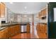 Well-lit kitchen with stainless steel appliances, hardwood floors, a breakfast bar, and granite countertops at 313 Young James Cir, Stockbridge, GA 30281