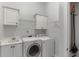 Bright laundry room featuring a washer, dryer, sink, and ample cabinet space at 4011 Charrwood Trce, Marietta, GA 30062