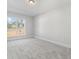 Bright bedroom features a window providing natural light with neutral-colored walls and carpet at 405 Nettle Ct, Woodstock, GA 30188