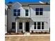 New construction townhome with white vertical siding, black trim, and manicured landscaping at 405 Nettle Ct, Woodstock, GA 30188