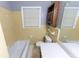 Simple bathroom with yellow tile and wood cabinet at 2555 Klondike Rd Sw, Conyers, GA 30094