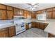 Galley kitchen with wood cabinets and white appliances at 2555 Klondike Rd Sw, Conyers, GA 30094