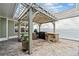 Outdoor kitchen and dining area with stone countertop, grill, pergola and brick patio at 320 Jessica Way, Canton, GA 30114