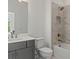 Gray vanity, white toilet and bathtub, and marble shower surround at 401 Nettle Ct, Woodstock, GA 30188