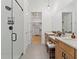 Modern bathroom features a glass-enclosed shower, dual vanities, and a view into the walk in closet at 401 Nettle Ct, Woodstock, GA 30188