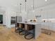 Bright kitchen featuring stainless steel appliances, white cabinets, a large island, and stylish pendant lighting, perfect for cooking at 401 Nettle Ct, Woodstock, GA 30188