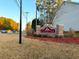 The Carriage Park community sign is framed by lush greenery, with cars passing on the adjacent road at 4547 Carriage Park Dr, Lithonia, GA 30038