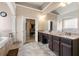 Luxury bathroom with dark cabinetry, tile floors, and granite countertops at 5269 Heron Bay Blvd, Locust Grove, GA 30248