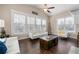 Sunlit living room with hardwood floors and an arrangement of white sofas and contemporary decor at 5269 Heron Bay Blvd, Locust Grove, GA 30248