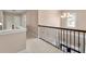 Upper level hallway features a stylish iron railing and neutral decor at 5269 Heron Bay Blvd, Locust Grove, GA 30248