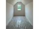 A view of the attic space with a window offering natural light at 679 Crest Line Trl, Powder Springs, GA 30127