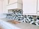 Close-up of stylish backsplash with neutral and blue toned scallop design adding a unique touch to the kitchen at 679 Crest Line Trl, Powder Springs, GA 30127