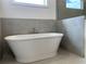 Bathroom featuring a soaking tub with modern fixtures and tile at 679 Crest Line Trl, Powder Springs, GA 30127