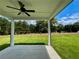 View from the covered patio shows the spacious lawn and green trees in the backyard at 679 Crest Line Trl, Powder Springs, GA 30127