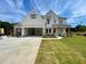 New construction home featuring a three-car garage, covered front porch, and large yard at 679 Crest Line Trl, Powder Springs, GA 30127