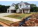 New home boasts white brick and siding, complemented by a manicured lawn and newly installed sidewalk at 679 Crest Line Trl, Powder Springs, GA 30127