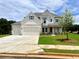 Beautiful two-story home boasts manicured lawn, white brick facade and a three-car garage at 679 Crest Line Trl, Powder Springs, GA 30127