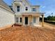 New home with a brick facade, charming porch with timber columns, and blue shutters, ready for landscaping at 679 Crest Line Trl, Powder Springs, GA 30127