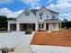 Two-story home boasting white brick, a three-car garage, and blue shutters, set on a landscaped lot at 679 Crest Line Trl, Powder Springs, GA 30127