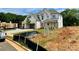 A two-story home featuring a three-car garage, pristine brick, manicured lawn, and some construction materials present at 679 Crest Line Trl, Powder Springs, GA 30127