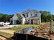 Exterior of new construction home featuring a three-car garage, brick and siding accents, and green front lawn at 679 Crest Line Trl, Powder Springs, GA 30127
