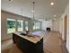 Open kitchen and living area with a dark island, modern fixtures, and a cozy fireplace at 679 Crest Line Trl, Powder Springs, GA 30127