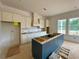 Unfinished kitchen featuring cream cabinets, a dark blue island and natural light from a window at 679 Crest Line Trl, Powder Springs, GA 30127