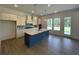 Modern kitchen with a large island, white cabinets, quartz countertops, and stainless steel appliances at 679 Crest Line Trl, Powder Springs, GA 30127