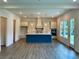 Bright kitchen features a large island with a sink, pendant lighting, and stainless steel appliances at 679 Crest Line Trl, Powder Springs, GA 30127