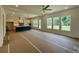 Open-concept living room leading to a kitchen with ample windows showcasing the outdoor view at 679 Crest Line Trl, Powder Springs, GA 30127