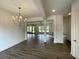Open concept living room features modern chandelier, neutral walls, wood floors, and fireplace at 679 Crest Line Trl, Powder Springs, GA 30127