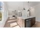 Open living space featuring a kitchen island, stone fireplace, and built-in shelving, filled with natural light at 679 Crest Line Trl, Powder Springs, GA 30127