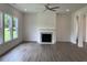 Living room featuring hardwood floors, a fireplace, and large windows offering ample natural light at 679 Crest Line Trl, Powder Springs, GA 30127