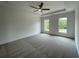Carpeted main bedroom with a tray ceiling, fan and two windows with natural light at 679 Crest Line Trl, Powder Springs, GA 30127