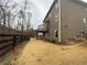 View of the brown two-story home and large backyard with a sturdy, dark wood fence at 1320 Newbridge Cir, Buford, GA 30519