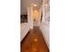 Elegant hallway featuring hardwood floors and seamless transitions between the kitchen, staircase, and living spaces at 1320 Newbridge Cir, Buford, GA 30519