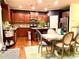 Well-lit kitchen with dark cabinets, stainless steel appliances, and an adjacent dining area at 1320 Newbridge Cir, Buford, GA 30519