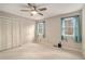 Cozy bedroom featuring a ceiling fan, carpeted floor, and double windows with bright light at 1519 Carnaby Ct, Dunwoody, GA 30338