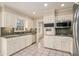 Well-lit kitchen featuring white cabinets, stainless steel appliances, and tile flooring at 1519 Carnaby Ct, Dunwoody, GA 30338