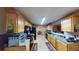 Kitchen with light wood cabinets, black appliances, and view to dining area at 5789 Star Flower Dr, Ellenwood, GA 30294