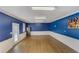 Bonus room with hardwood floors, white wainscoting, and bright blue walls at 202 Heights Pl, Canton, GA 30114