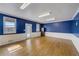 Bonus room featuring hardwood floors, white wainscoting, bright blue walls and natural light at 202 Heights Pl, Canton, GA 30114